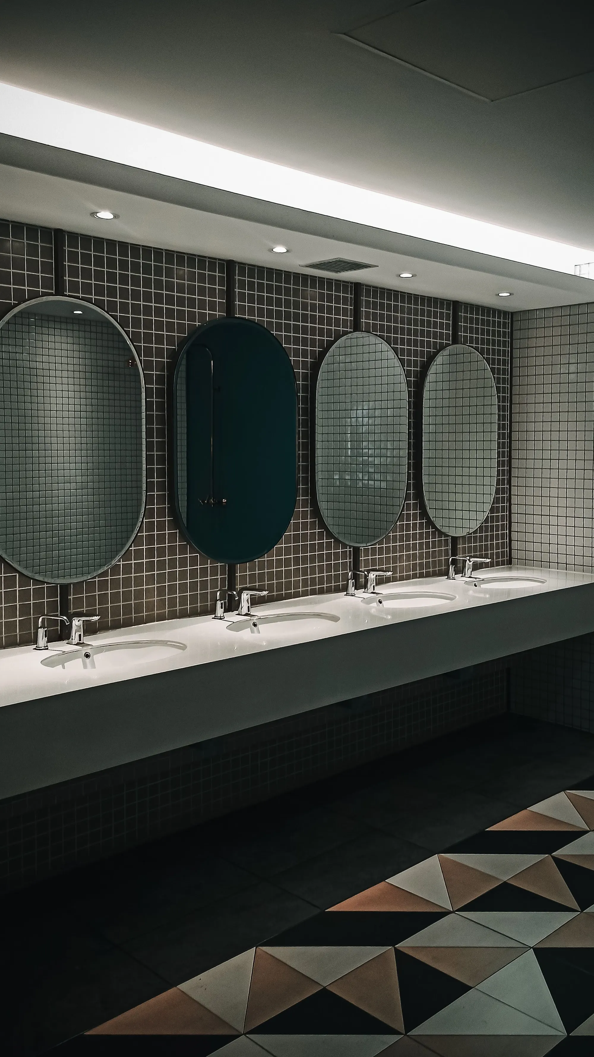 Commercial washroom with green mosaic tiles