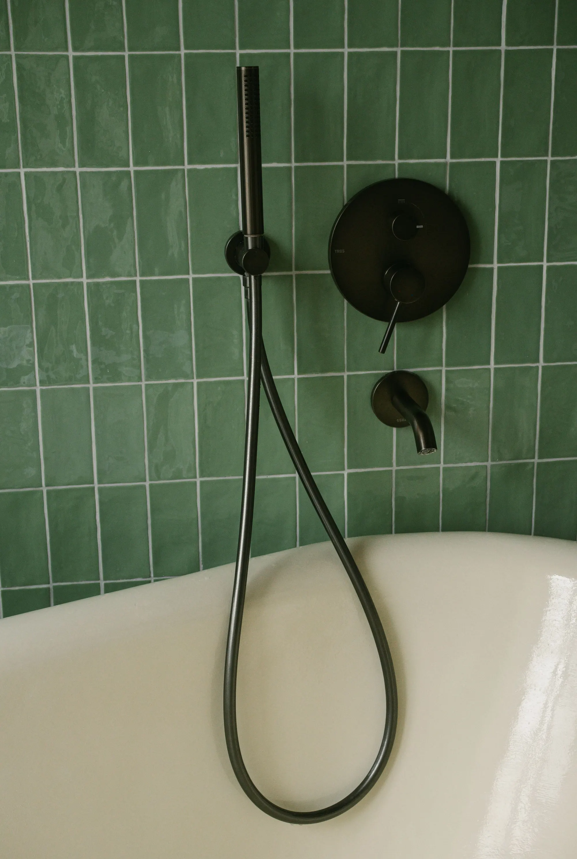 Green square wall tiles with black tapware