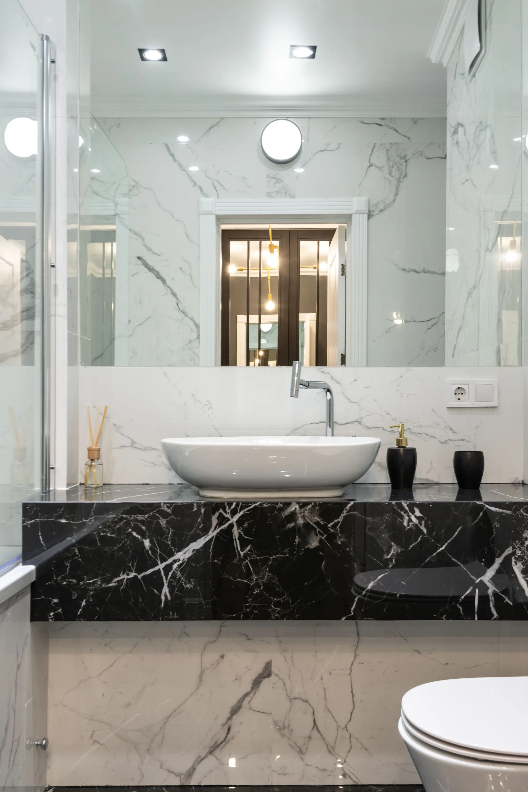Marble-look bathroom with a black stone vanity