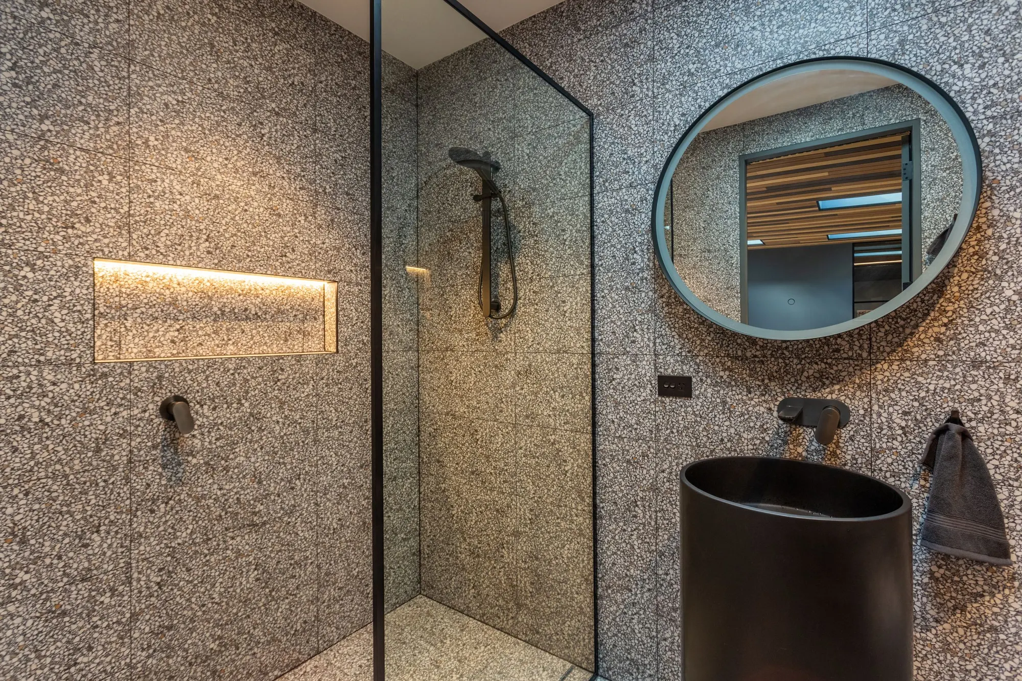 Terrazzo shower with a round mirror