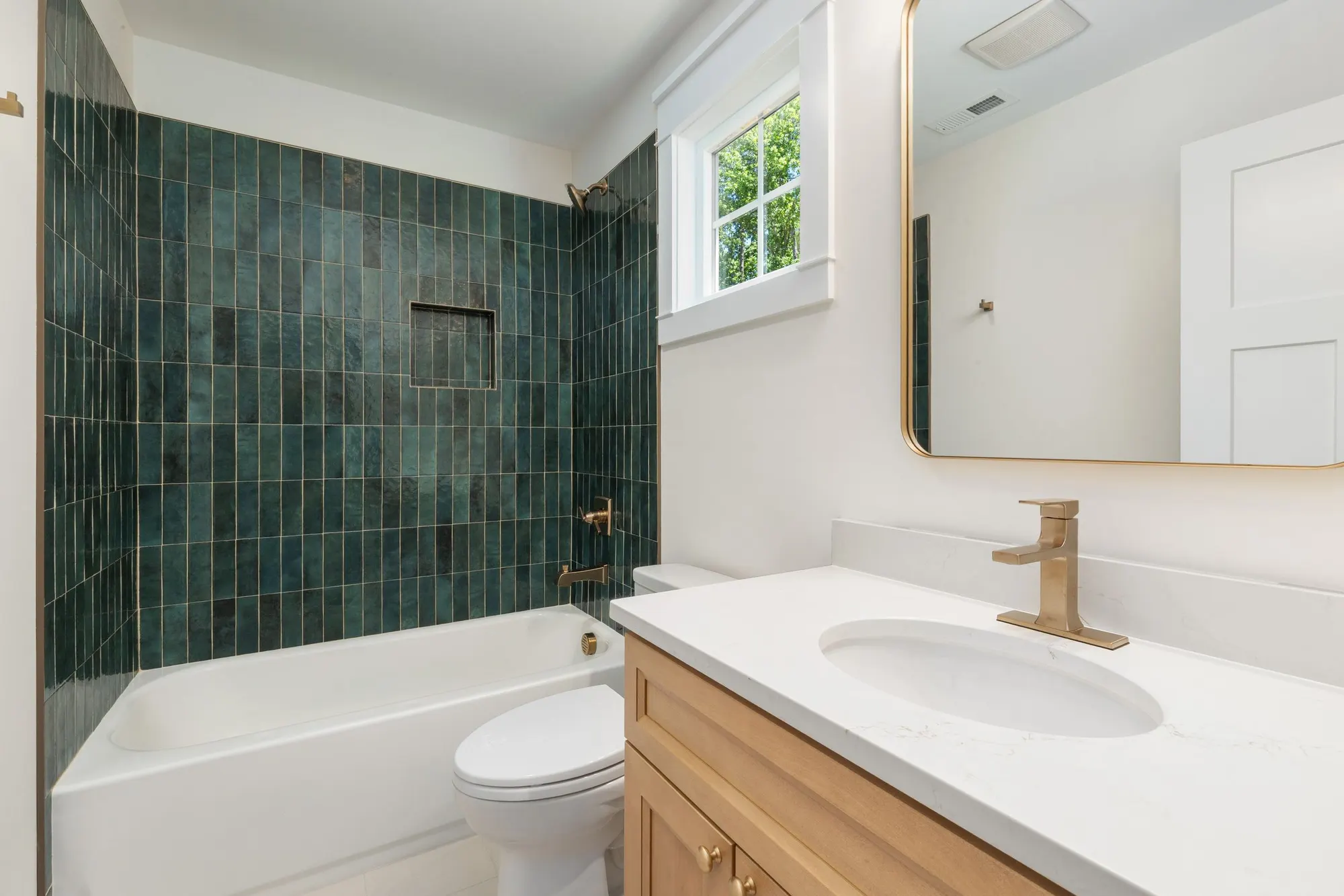 Green zellige tiles behind a white vanity